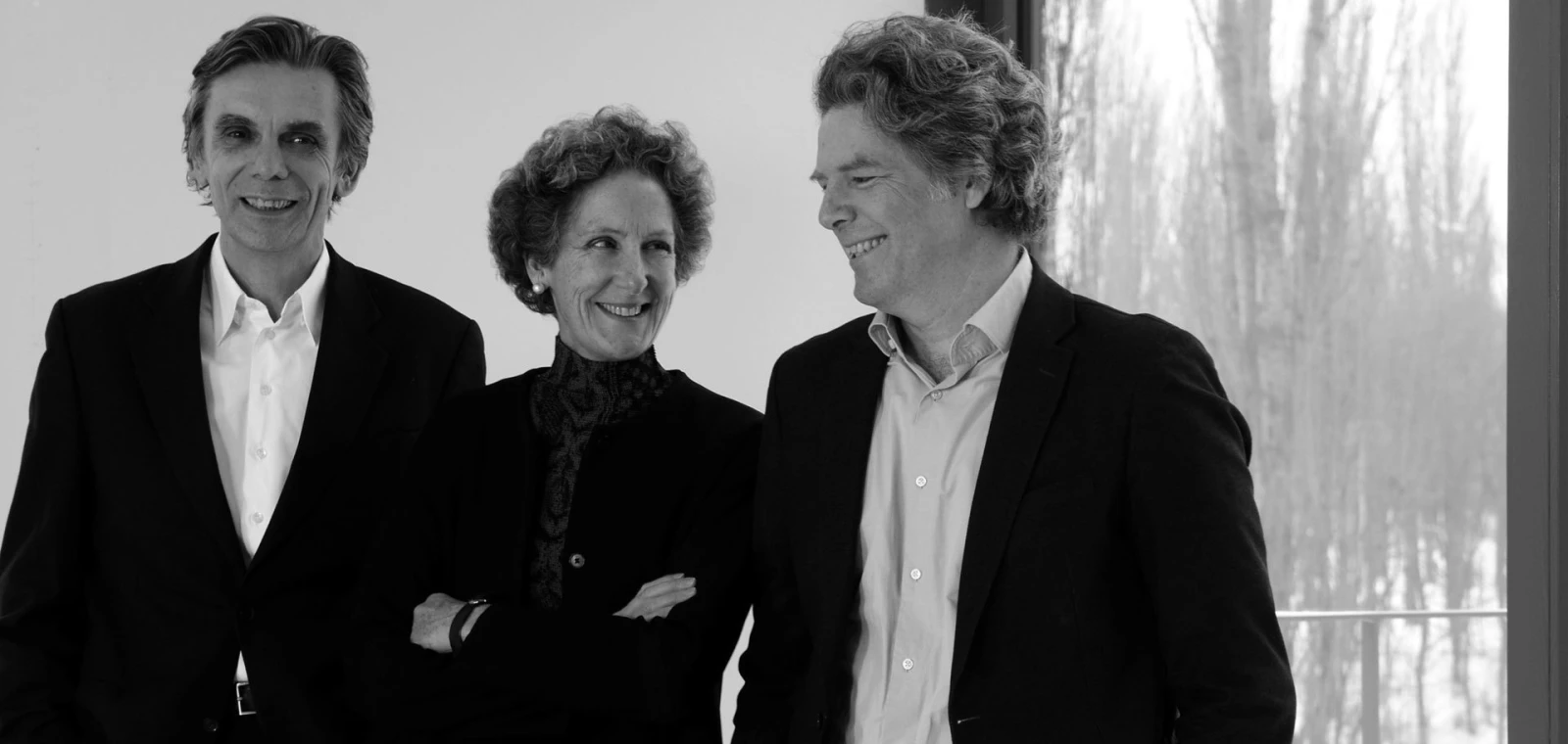 Black-and-white portrait of the Sauerbruch Hutton practice members in Berlin. From left to right the two founders Matthias Sauerbruch and Louisa Hutton plus their partner Juan Lucas Young.
